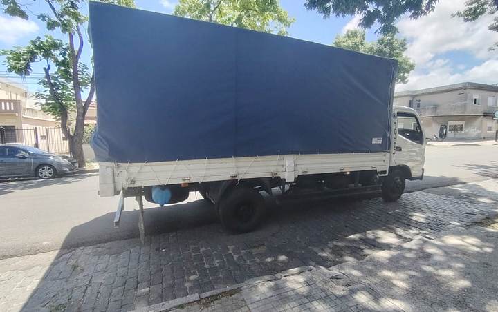 Camión con lona azul para fletes estacionado en una calle de Montevideo