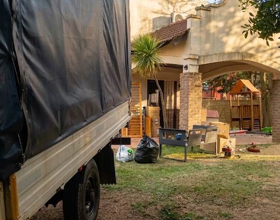 Camión con lona frente a una casa durante una mudanza al interior